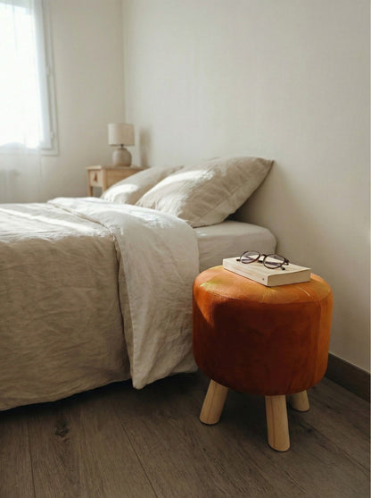 Puff color cobre en dormitorio junto a la cama, asiento auxiliar decorativo