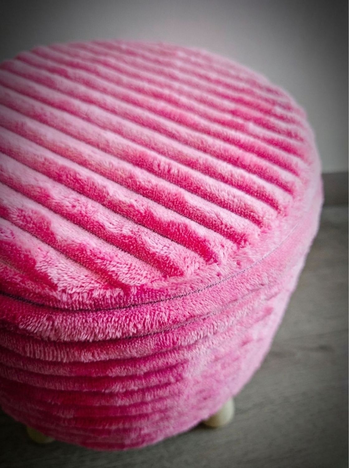 Detalle de la textura acanalada del puff rosa, vista superior del tapiz