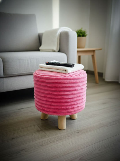 Puff rosa acolchado en living, asiento auxiliar compacto con patas de madera